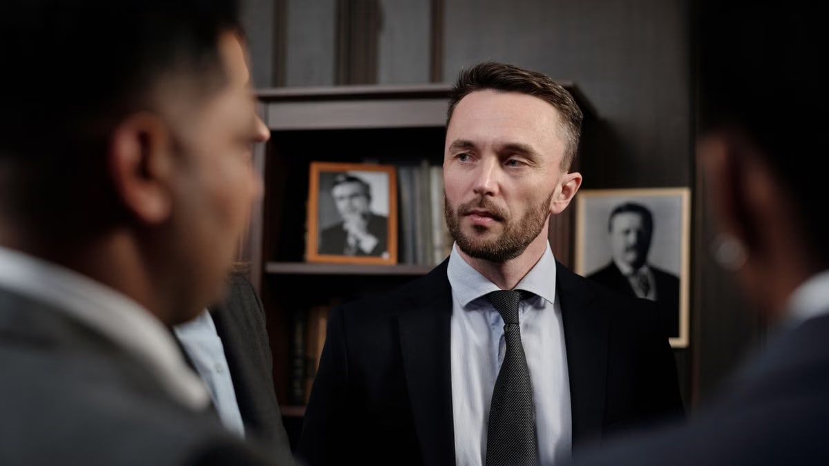 Group of men in suits having a serious business discussion in a professional setting.